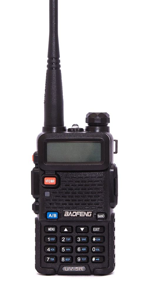 A black Baofeng UV-5R dual-band handheld transceiver with a rubber-duck antenna, a small LCD screen and a numeric keypad, photographed on a white background.